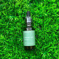 OC Beauty Co. Rosemary and peppermint hair oil bottle with fresh rosemary and peppermint sprigs, showcasing natural hair care ingredients.